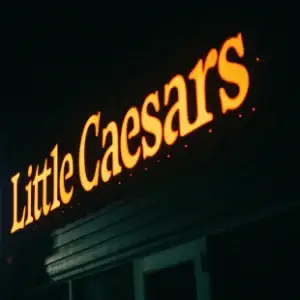 Enseigne lumineuse LED à rétro-éclairage orange, réalisée sur mesure par Bizzi Enseigne