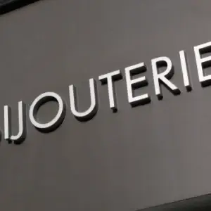 Enseigne en aluminium de haute qualité, vue en gros plan, montrant la finition métallique lisse et résistante du matériau.