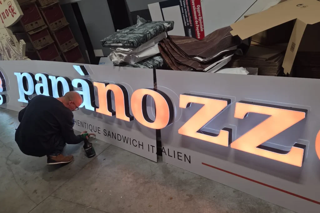 Assemblage d’une enseigne dans l’atelier Bizzi à Hem