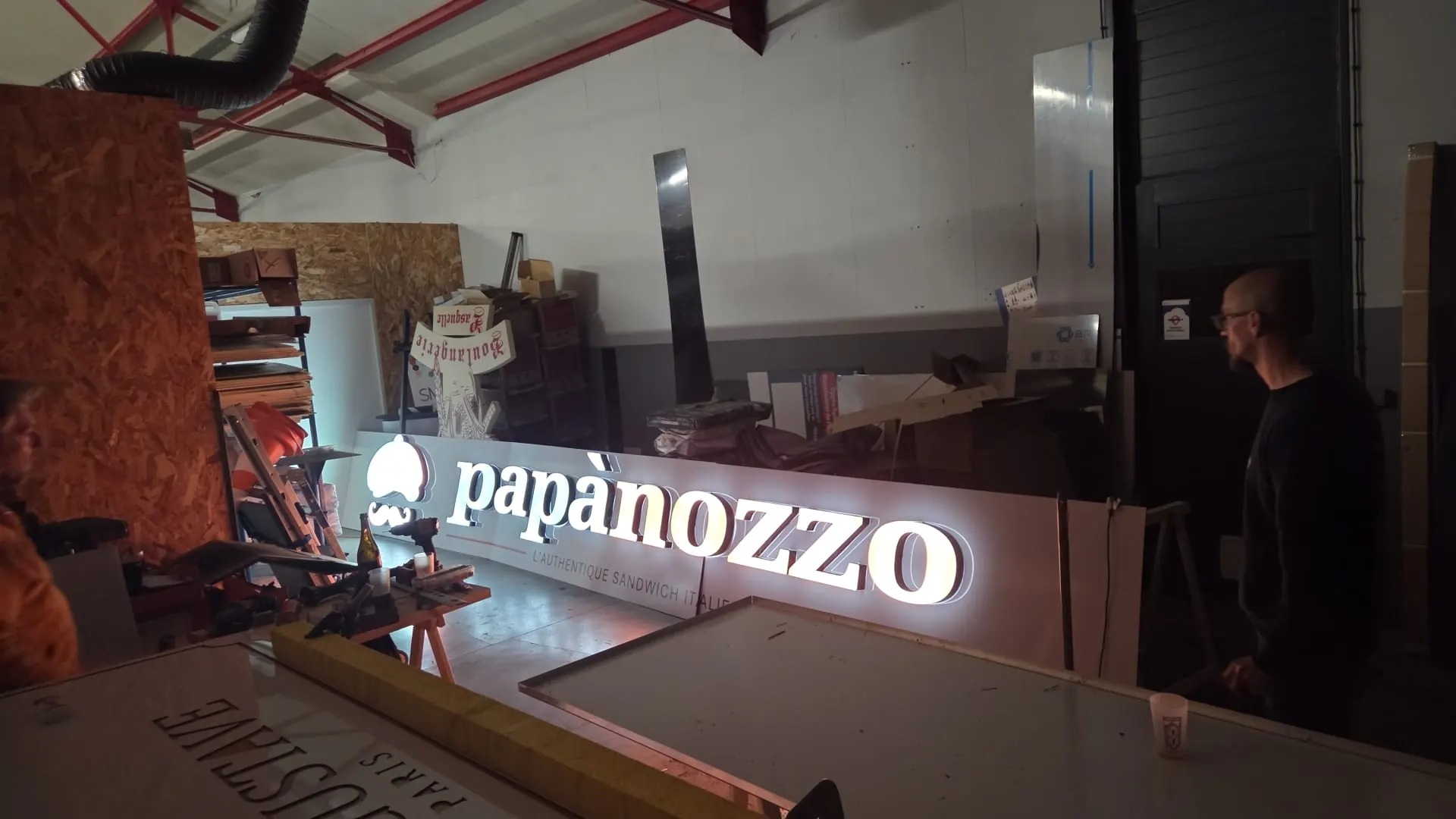 Lettres boîtier LED allumées dans l’atelier Bizzi Enseigne à Hem